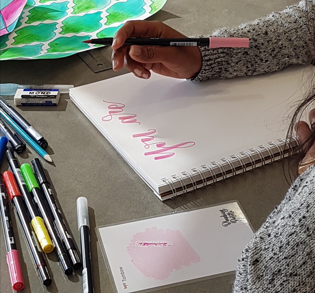 Usha Rajpal Cheddi continues to craft the phrase, "You are strong," using soft pink pen ink. Photo courtesy of: Usha Rajpal Cheddi.