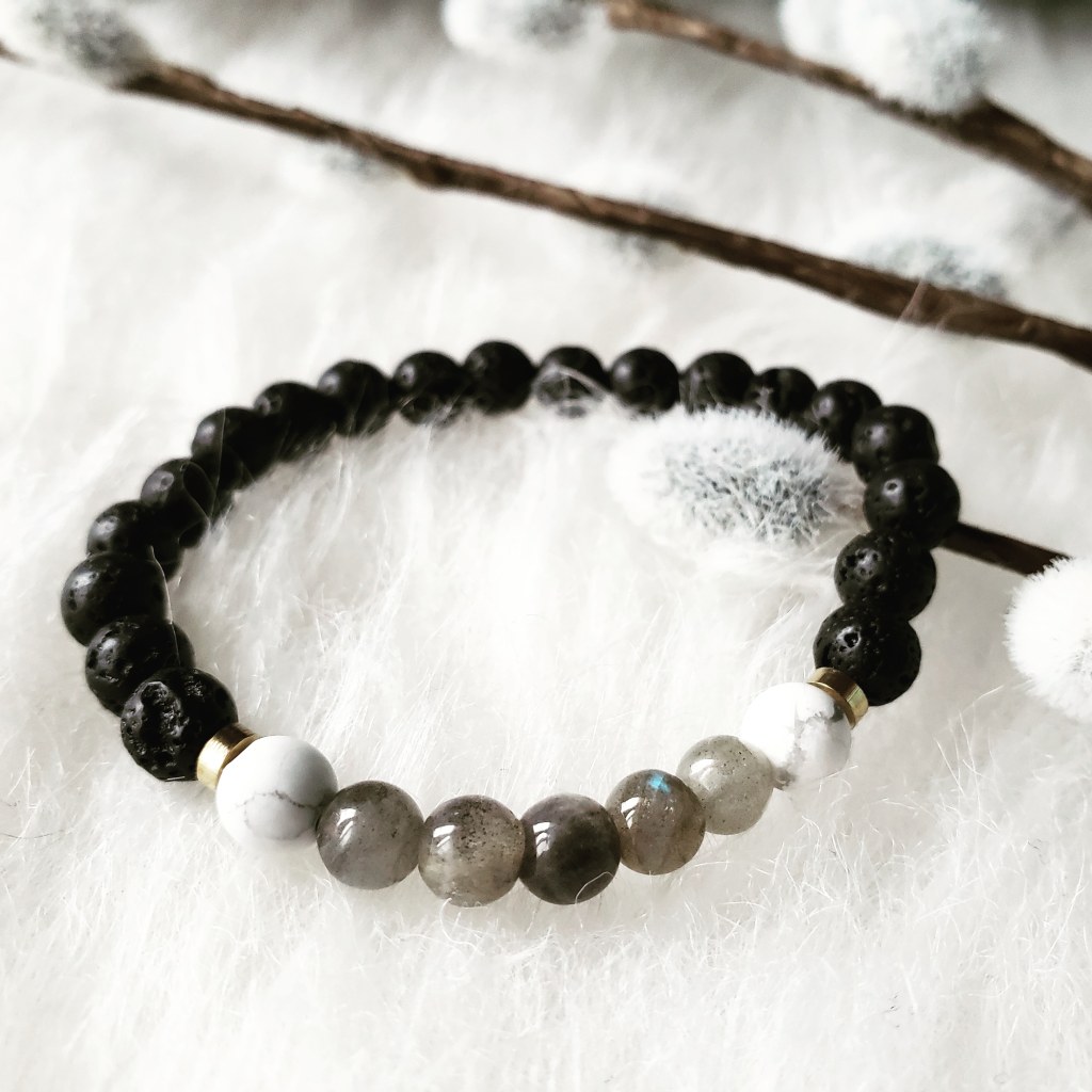 A Howlite and Labradorite stone bracelet by Trias. Photo by; Alvia Giash. Black stones make up most of this bracelet, with marble white and grey stones collecting at the middle, paired with two subtle gold beads. Photo by: Alvia Giash. 